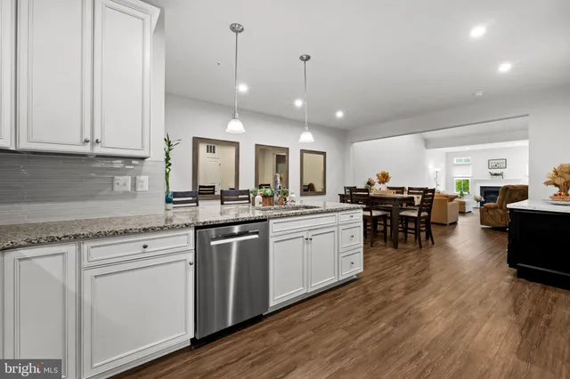a kitchen with stainless steel appliances a refrigerator and a wooden floor