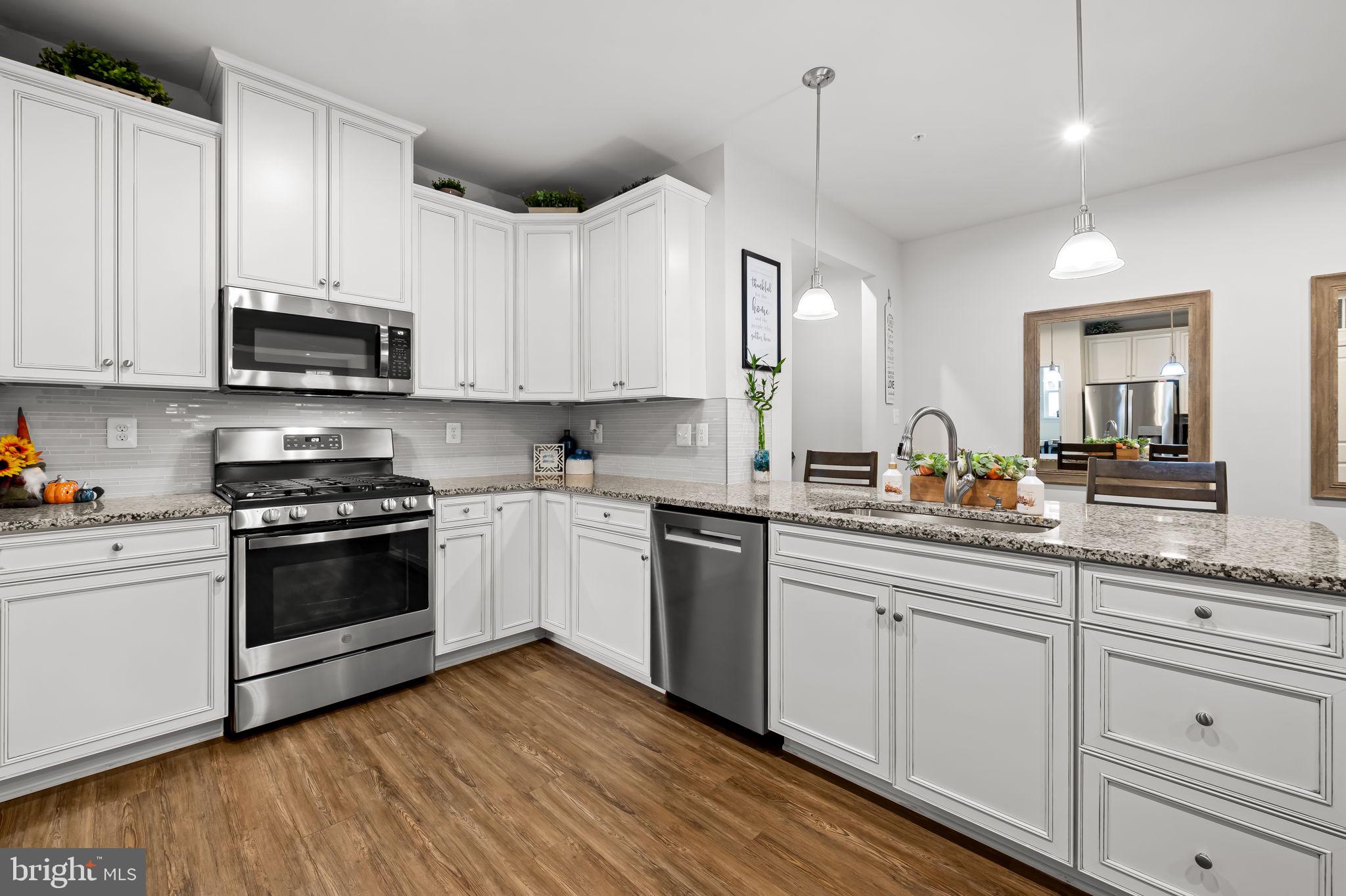 7728 Pestle Lane Glen Burnie, MD 21060 - Photo 9 of 66 a kitchen with granite countertop a sink cabinets and stainless steel appliances