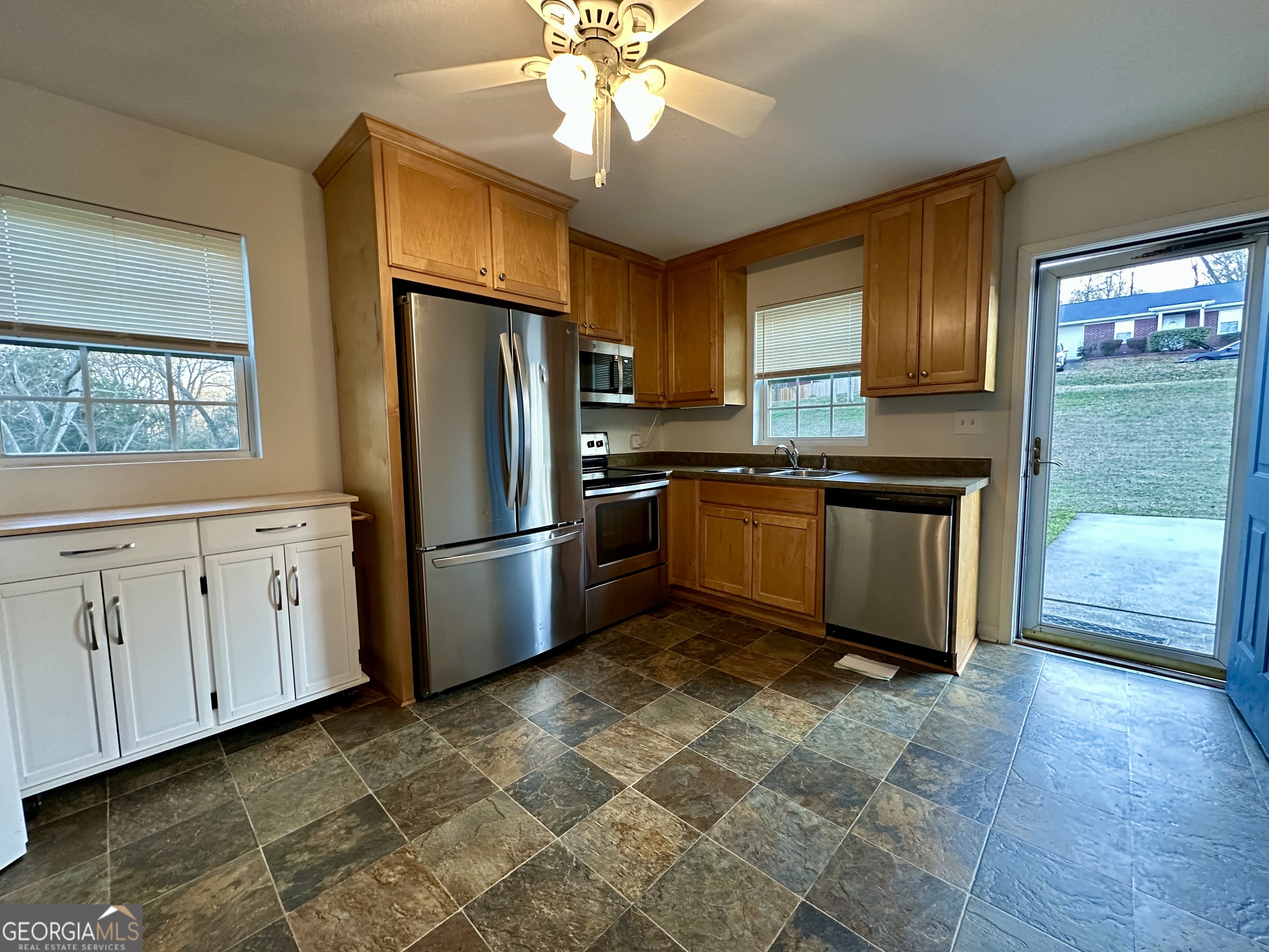 122 Forest Avenue Commerce, GA 30529 - Photo 4 of 17 a kitchen with stainless steel appliances granite countertop a refrigerator a sink dishwasher a stove with wooden cabinets and floor
