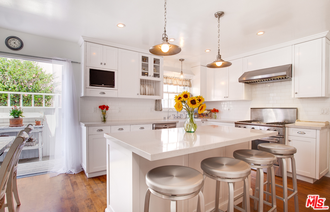 2327 Eastern Court Venice, CA 90291 - Photo 16 of 44 a kitchen with stainless steel appliances kitchen island granite countertop a sink a stove a dining table and chairs with wooden floor