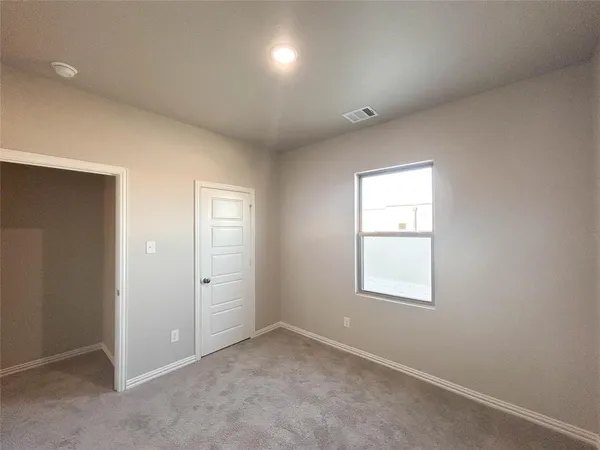 an empty room with windows and closet