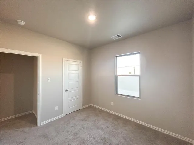 an empty room with windows and closet