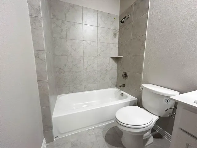 a bathroom with a toilet and a bath tub