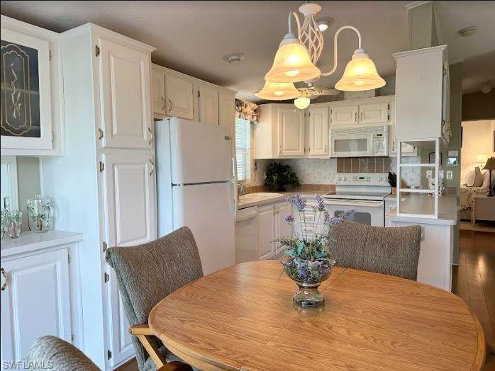 554 Cattleya Refuge, Unit 554 Naples, FL 34114 - Photo 24 of 49 a kitchen with stainless steel appliances kitchen island granite countertop a refrigerator a sink a stove and white cabinets