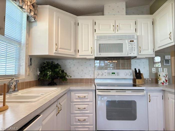 554 Cattleya Refuge, Unit 554 Naples, FL 34114 - Photo 26 of 49 a kitchen with cabinets appliances a sink and a counter top space