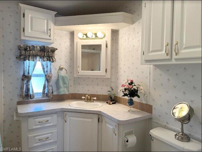 554 Cattleya Refuge, Unit 554 Naples, FL 34114 - Photo 30 of 49 a bathroom with a sink and a mirror