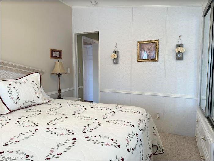 554 Cattleya Refuge, Unit 554 Naples, FL 34114 - Photo 36 of 49 a bedroom with a bed and painting on the wall