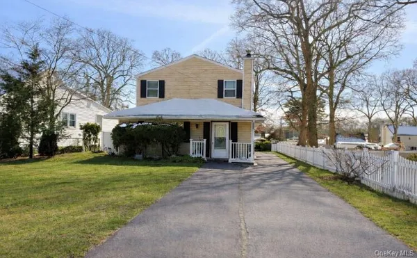 a front view of a house with a yard and trees