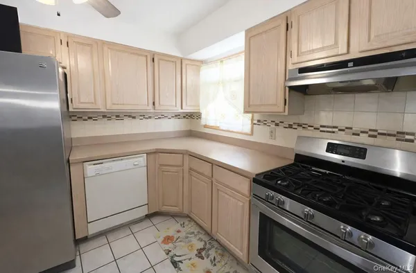 a kitchen with a stove white cabinets and black appliances