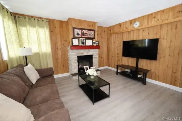 a living room with furniture a flat screen tv and a fireplace