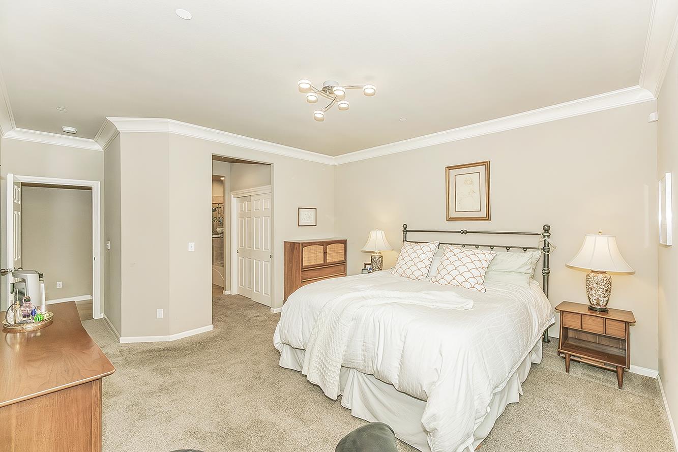 7133 North Generation Drive Fresno, CA 93711 - Photo 18 of 38 a bedroom with a bed and a chandelier