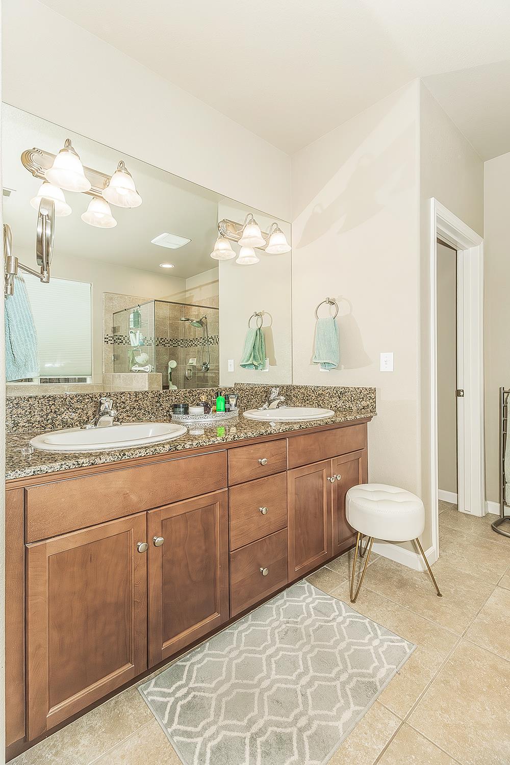 7133 North Generation Drive Fresno, CA 93711 - Photo 21 of 38 a bathroom with a granite countertop toilet sink and mirror