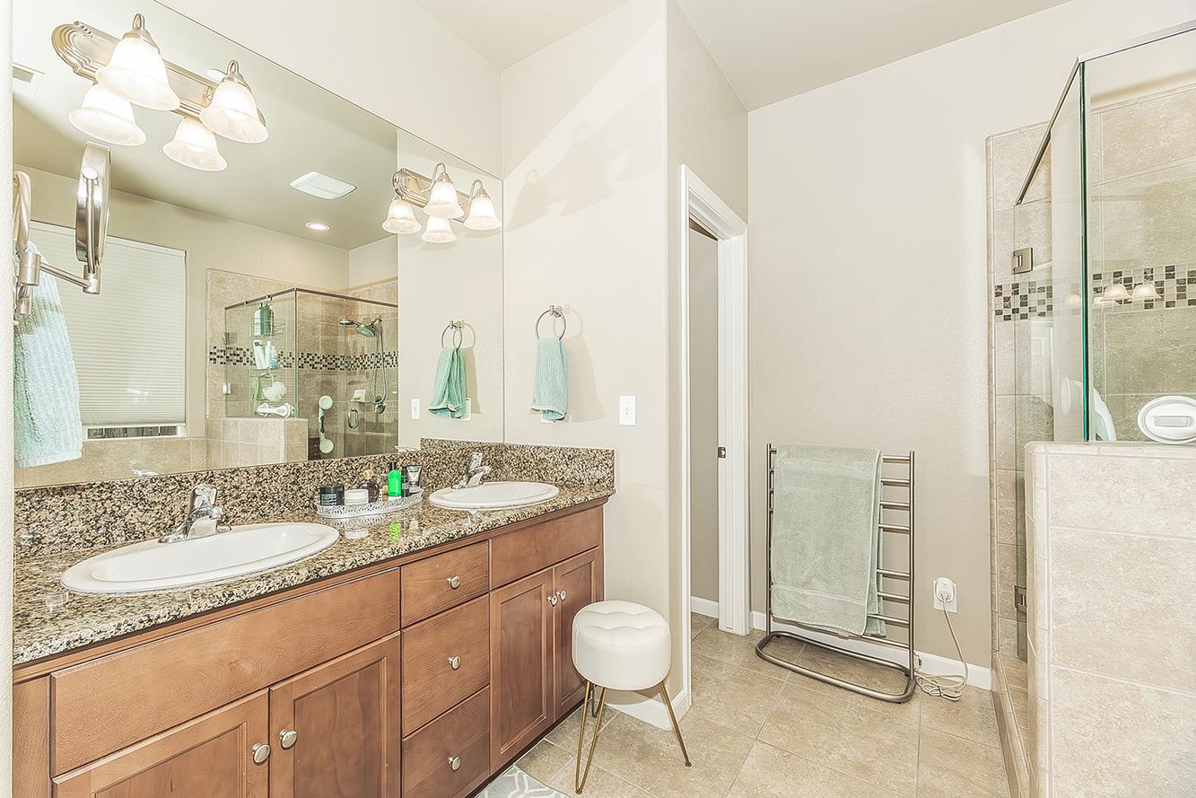 7133 North Generation Drive Fresno, CA 93711 - Photo 22 of 38 a bathroom with a granite countertop sink a toilet and a mirror