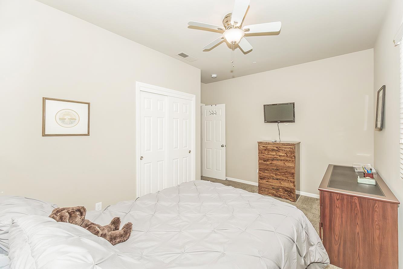 7133 North Generation Drive Fresno, CA 93711 - Photo 24 of 38 a bedroom with a bed and a chandelier