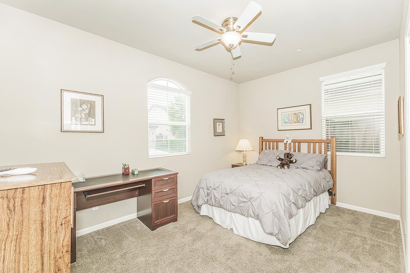 7133 North Generation Drive Fresno, CA 93711 - Photo 25 of 38 a bedroom with a bed and a chandelier