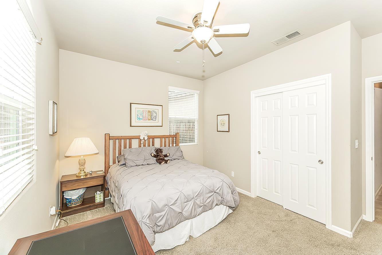 7133 North Generation Drive Fresno, CA 93711 - Photo 26 of 38 a bedroom with a bed and a chandelier