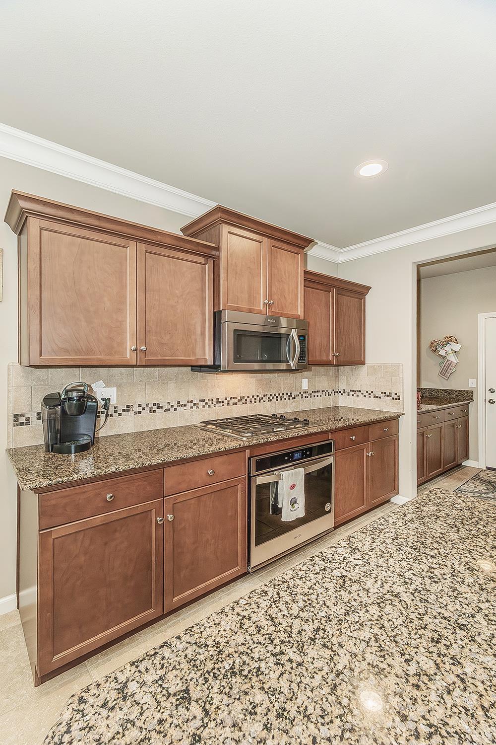 7133 North Generation Drive Fresno, CA 93711 - Photo 4 of 38 a kitchen with stainless steel appliances granite countertop a stove sink and cabinets