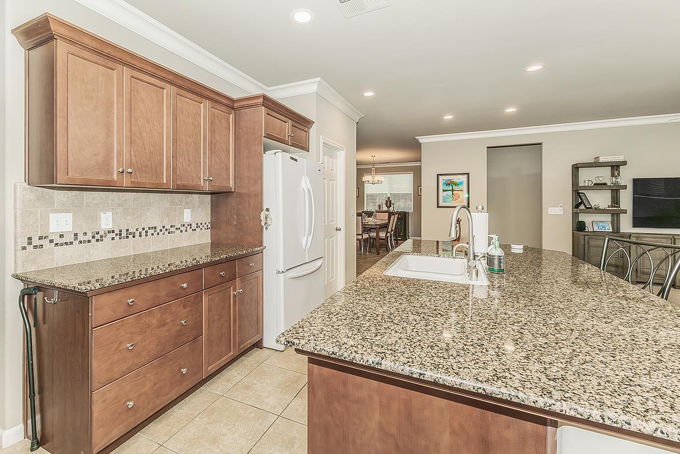 7133 North Generation Drive Fresno, CA 93711 - Photo 5 of 38 a kitchen with stainless steel appliances granite countertop a sink stove and refrigerator