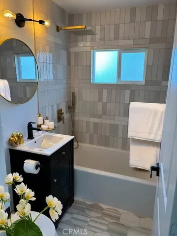 a bathroom with a sink mirror and tub