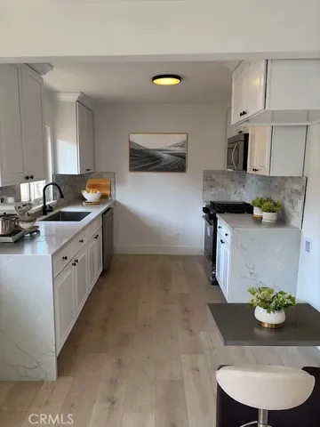 a kitchen with stainless steel appliances granite countertop a sink and a stove