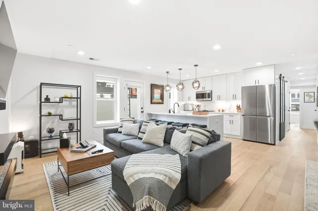 a living room with furniture white walls and wooden floor