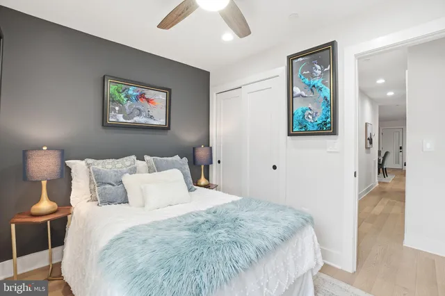 a bedroom with a bed and painting on the wall