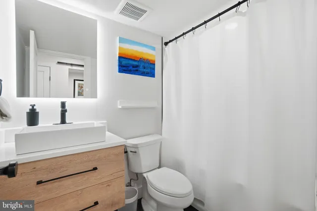 a white toilet sitting next to a bathroom sink