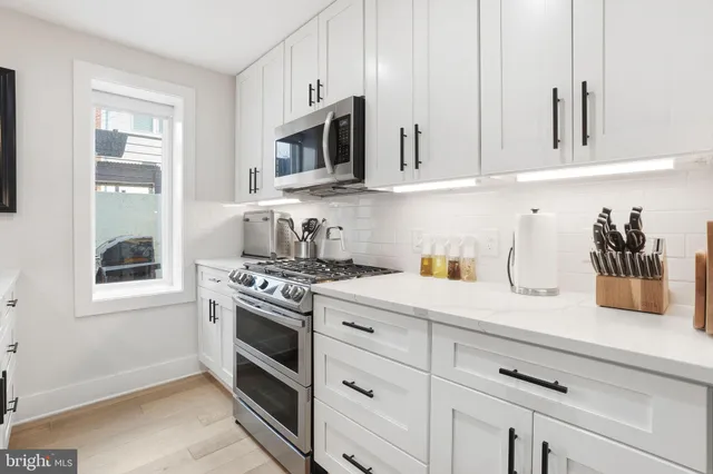 a kitchen with white cabinets and white appliances