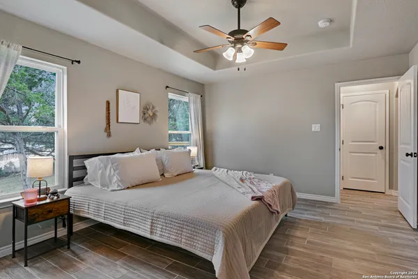 a bedroom with a large bed chandelier and a window