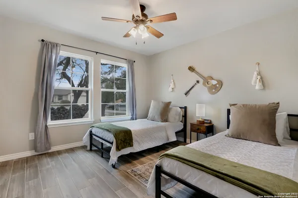 a bedroom with two beds and a large window