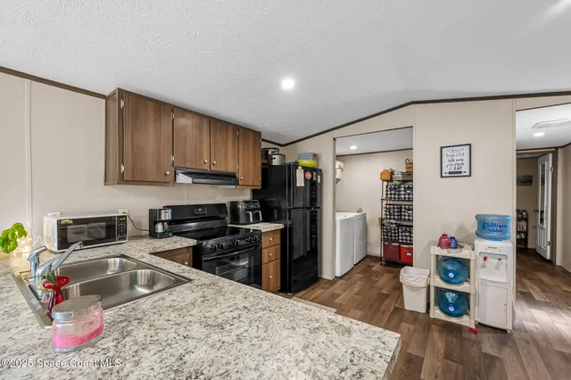 a kitchen with stainless steel appliances granite countertop a refrigerator sink and stove