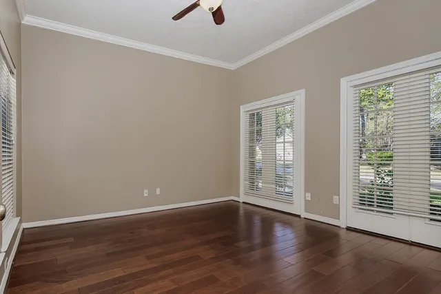 a view of a livingroom with wooden floor and a large window