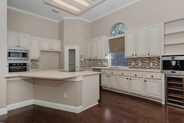 a kitchen with stainless steel appliances kitchen island granite countertop a stove and a sink