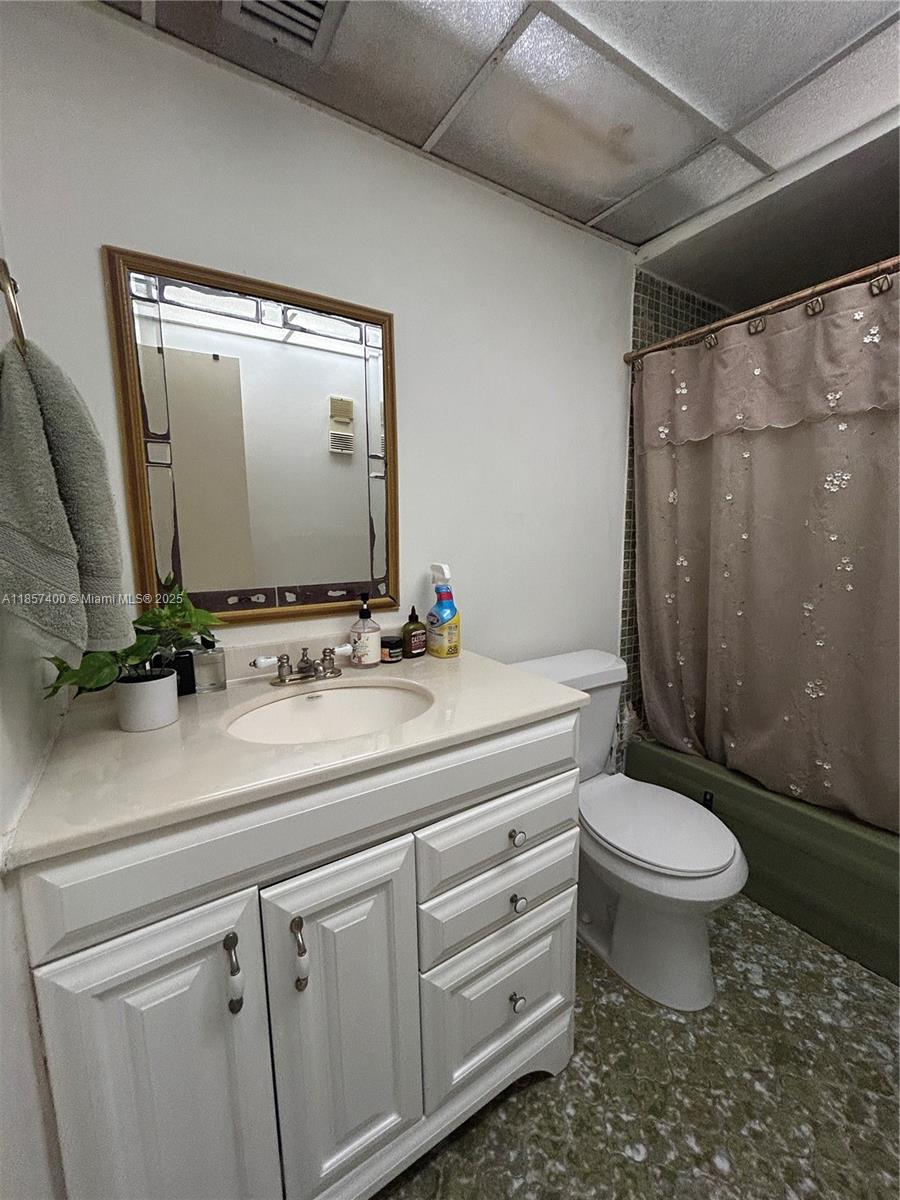 14201 Southwest 66th Street, Unit 306 Miami, FL 33183 - Photo 12 of 38 a bathroom with a granite countertop sink toilet and a mirror