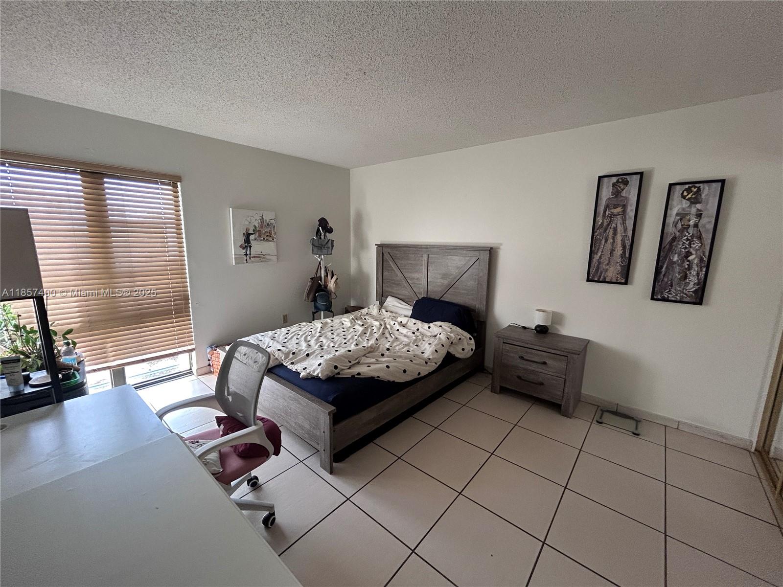 14201 Southwest 66th Street, Unit 306 Miami, FL 33183 - Photo 13 of 38 a bedroom with a bed and a couch next to a window