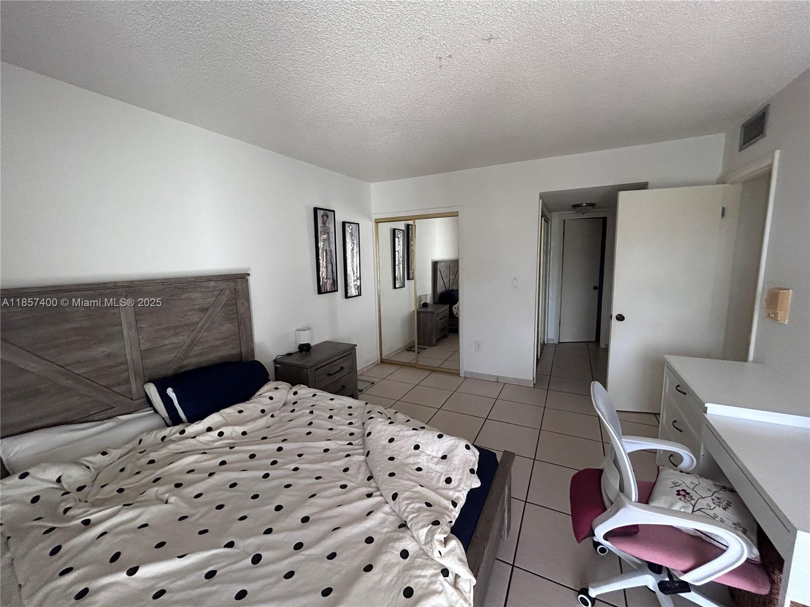 14201 Southwest 66th Street, Unit 306 Miami, FL 33183 - Photo 14 of 38 a bedroom with a bed and a chair