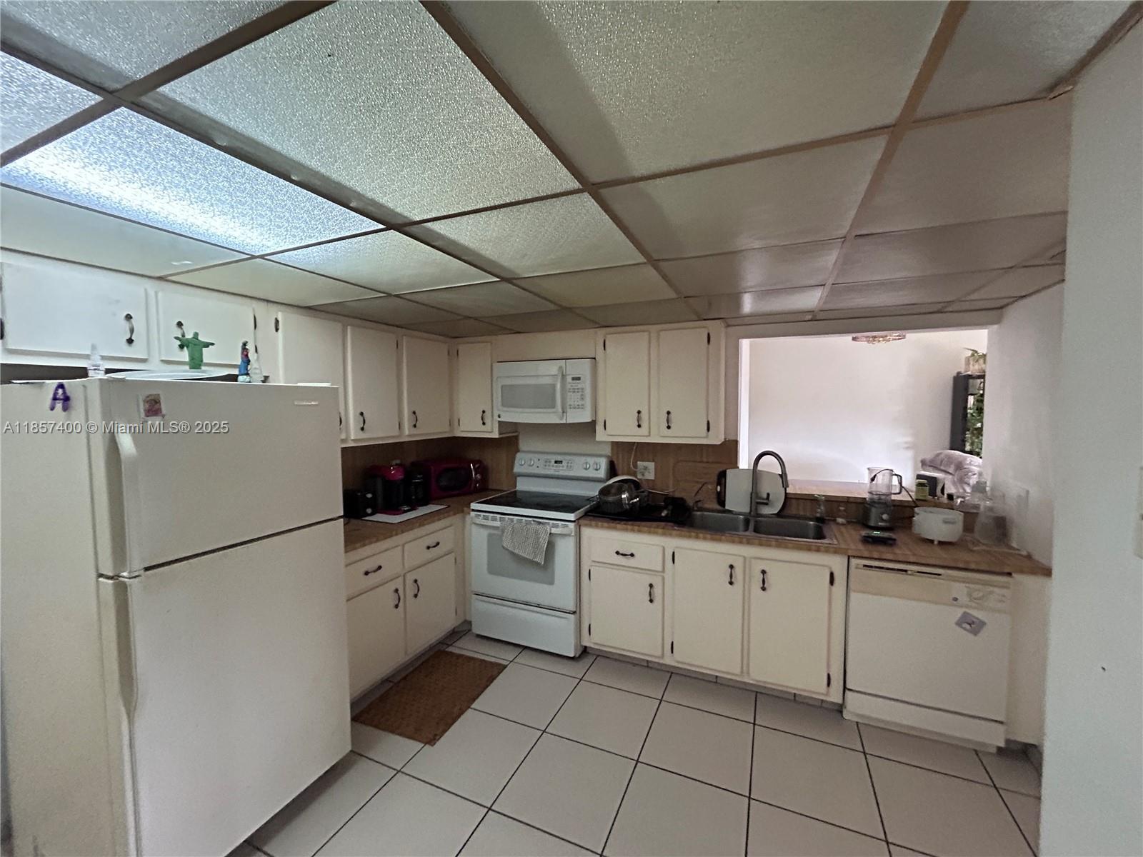 14201 Southwest 66th Street, Unit 306 Miami, FL 33183 - Photo 20 of 38 a kitchen with white cabinets sink and white appliances