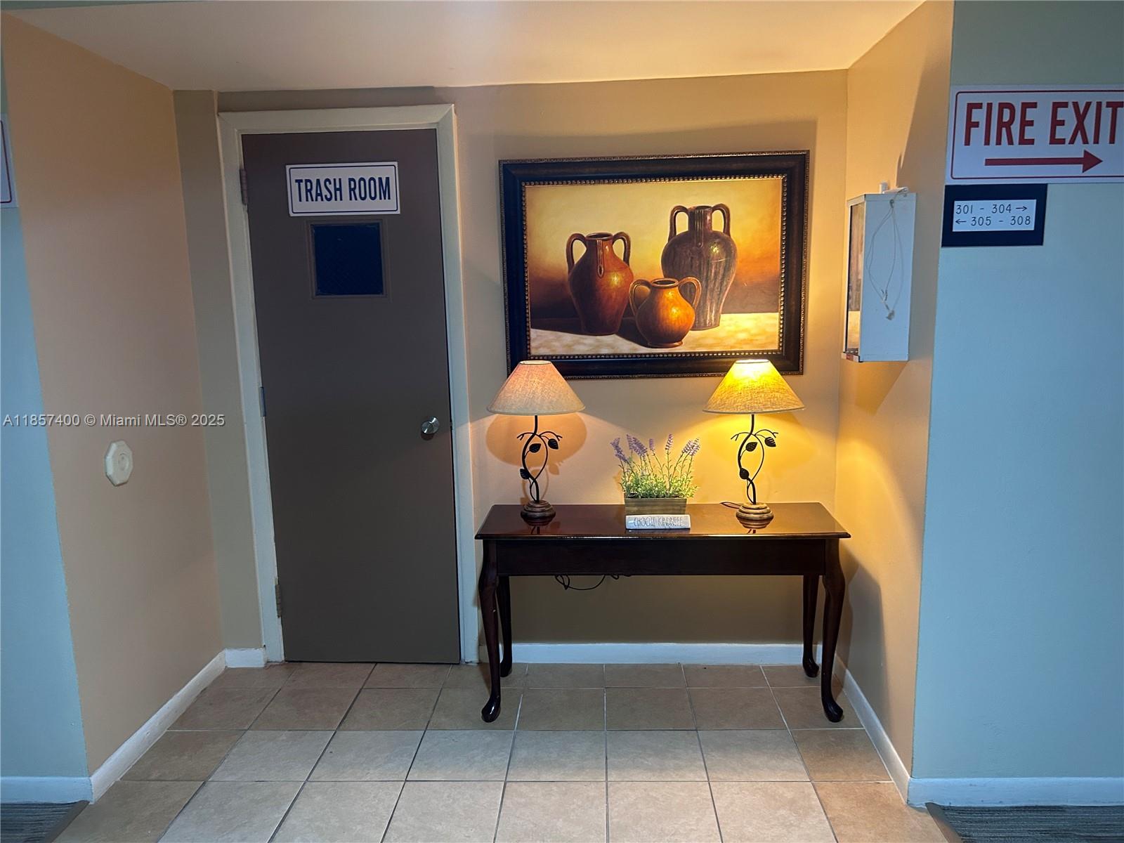 14201 Southwest 66th Street, Unit 306 Miami, FL 33183 - Photo 2 of 38 a view of a hallway that has painting on the wall and a potted plant