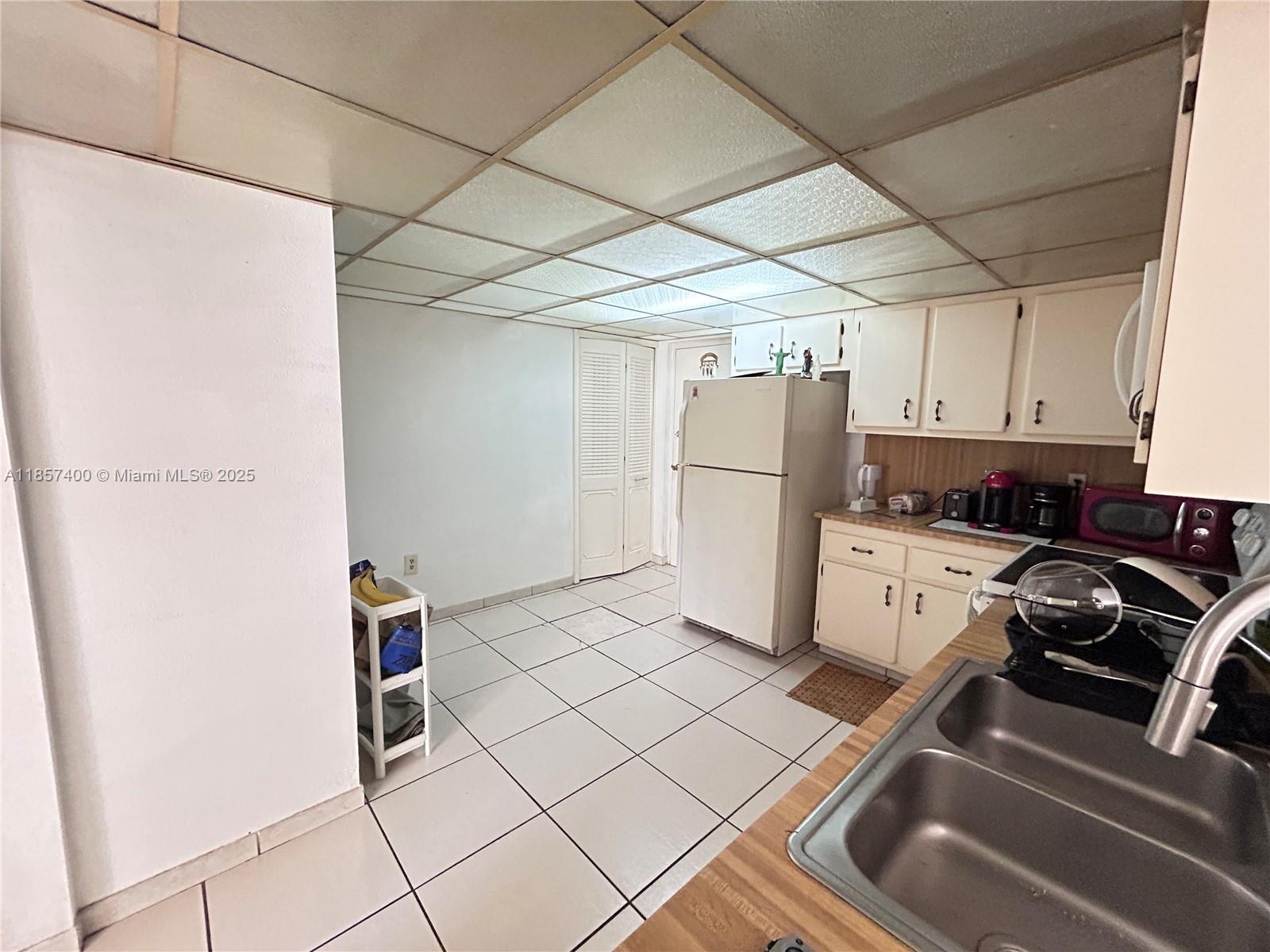 14201 Southwest 66th Street, Unit 306 Miami, FL 33183 - Photo 4 of 38 a kitchen with a refrigerator and a stove top oven