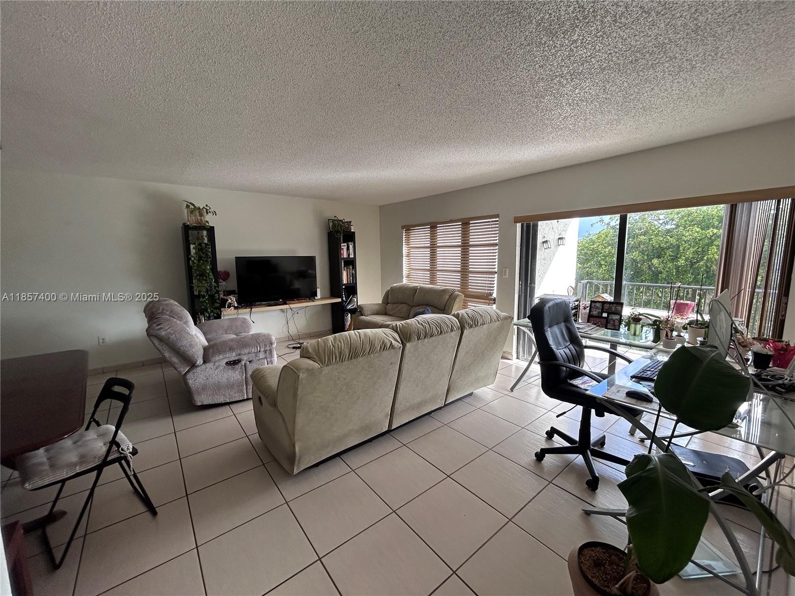 14201 Southwest 66th Street, Unit 306 Miami, FL 33183 - Photo 6 of 38 a living room with furniture and a large window
