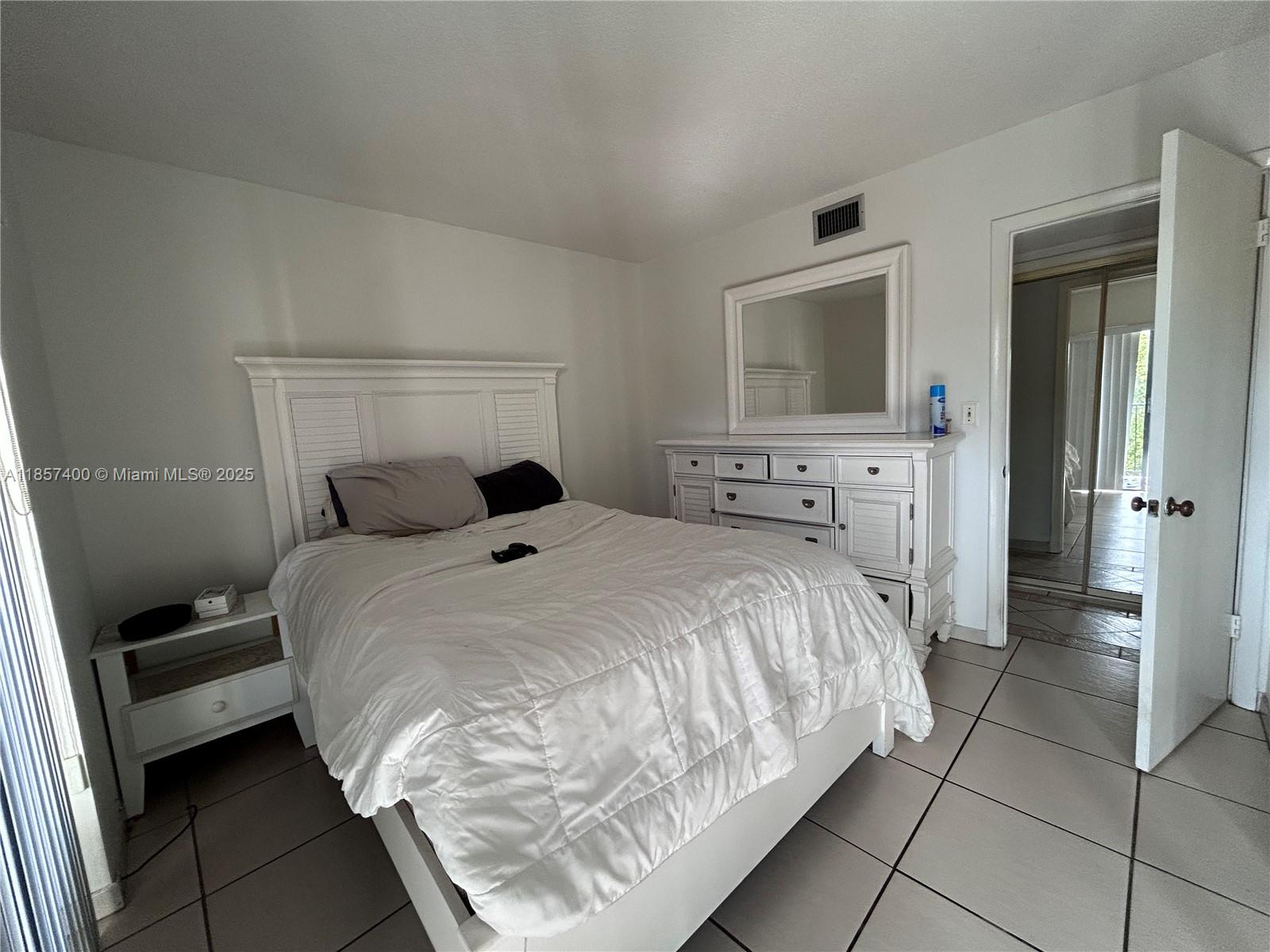 14201 Southwest 66th Street, Unit 306 Miami, FL 33183 - Photo 8 of 38 a bedroom with a bed and a dresser