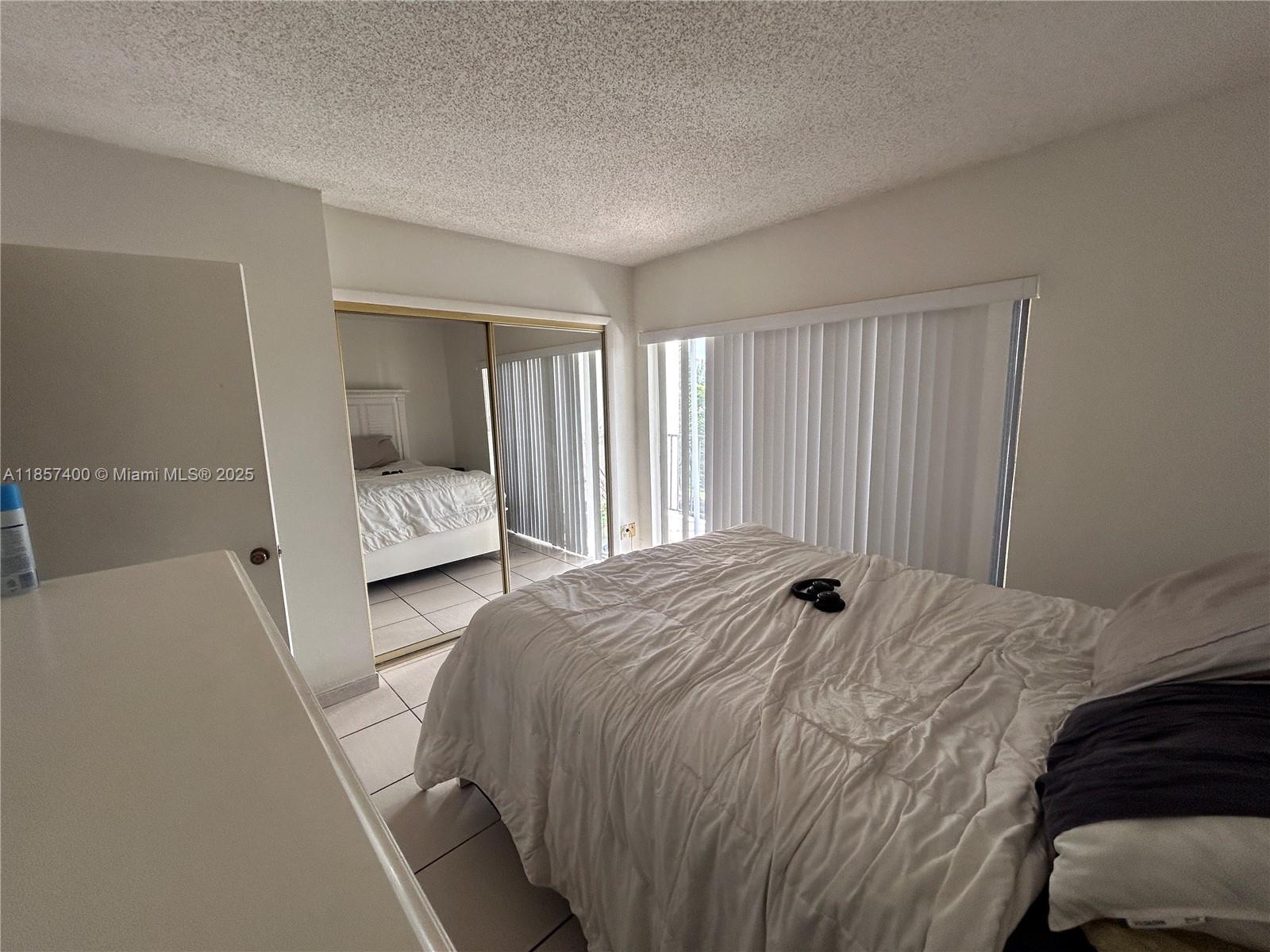 14201 Southwest 66th Street, Unit 306 Miami, FL 33183 - Photo 9 of 38 a bedroom with a bed and a window