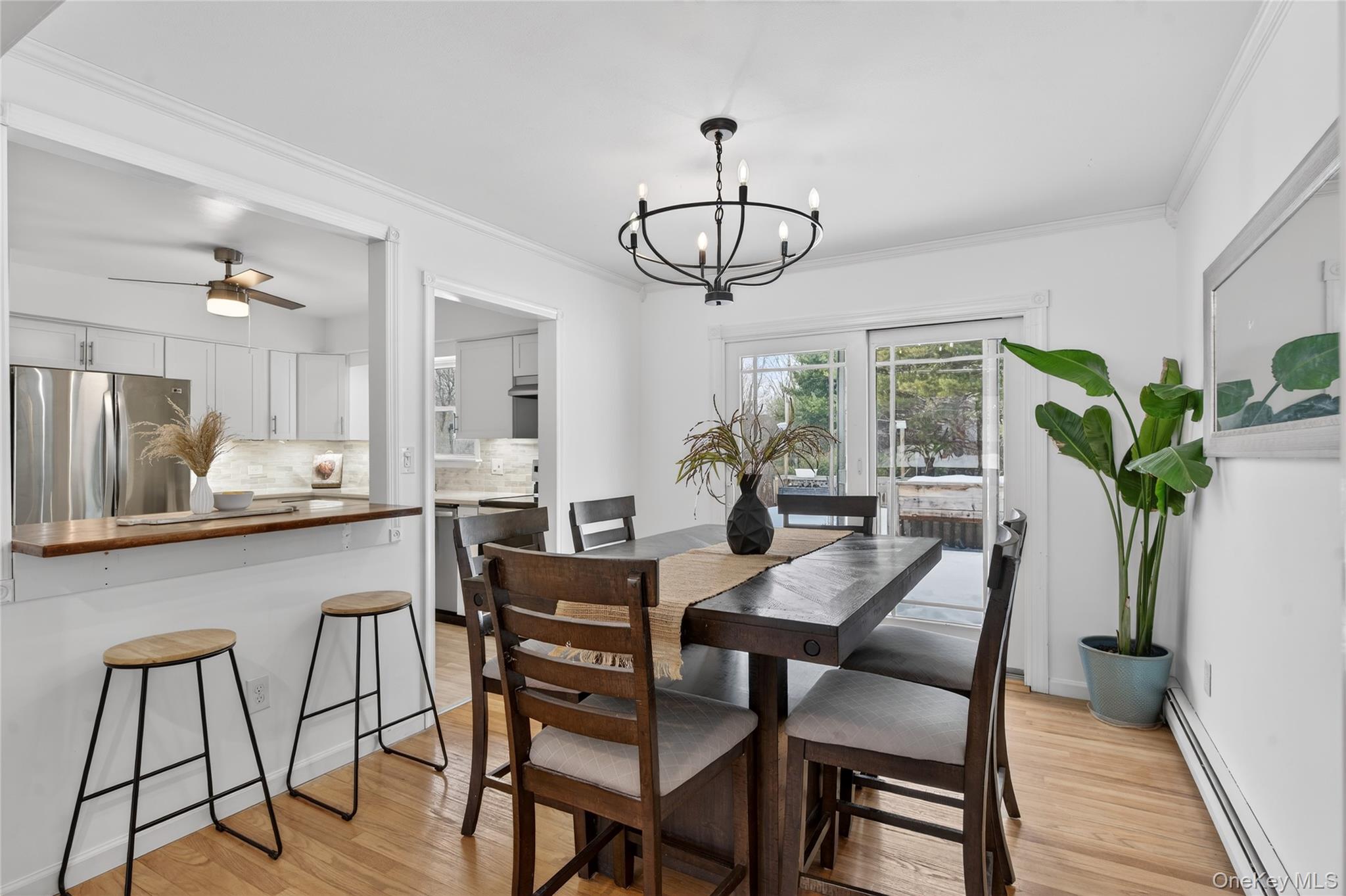 100 Watch Hill Drive Fishkill, NY 12524 - Photo 12 of 49 Dining area featuring baseboard heating, crown molding, light wood-type flooring, suspended lighting, and a ceiling fan
