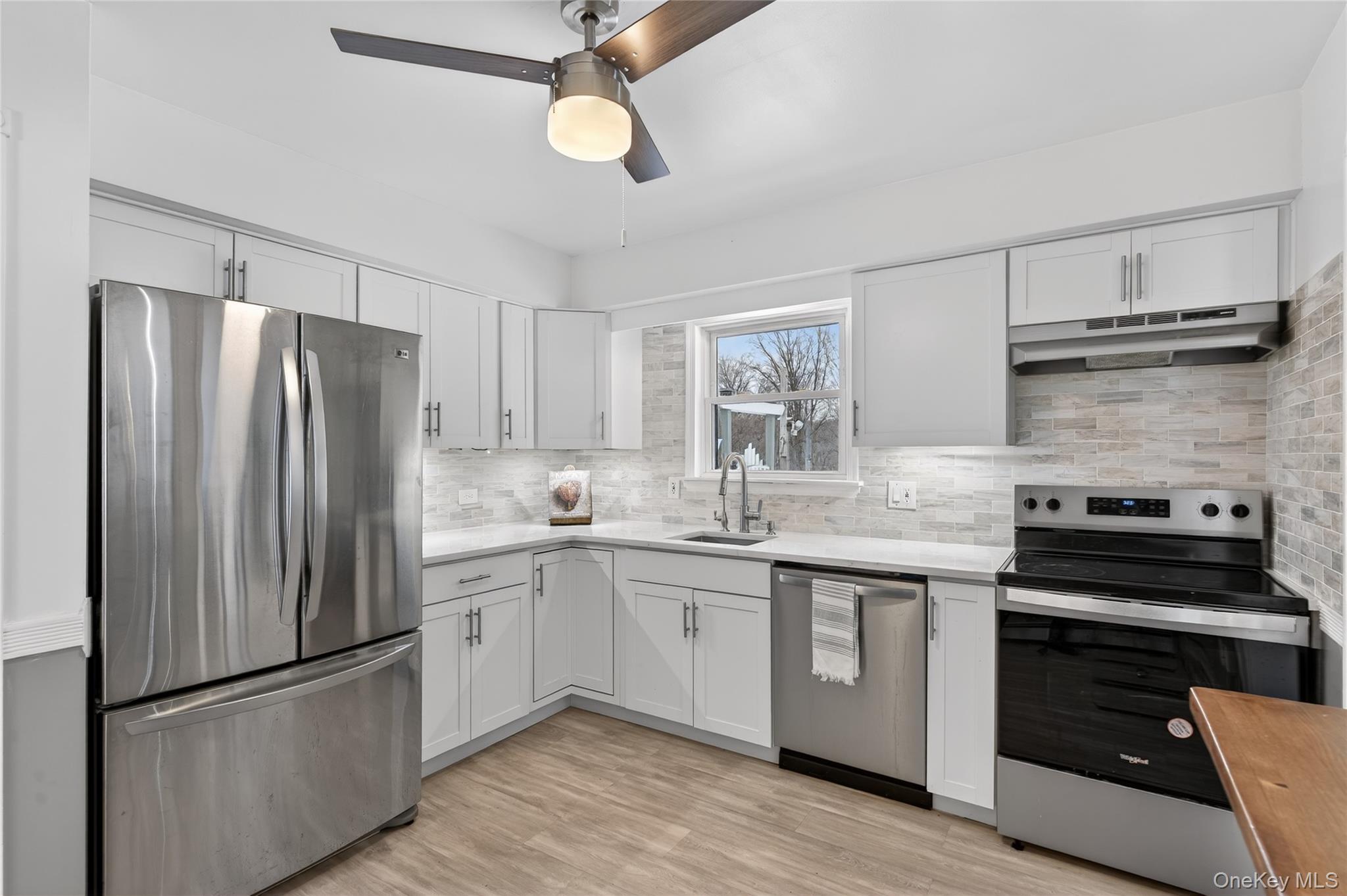 100 Watch Hill Drive Fishkill, NY 12524 - Photo 16 of 49 Kitchen with stainless steel appliances, light wood-style flooring, white cabinetry, and a ceiling fan