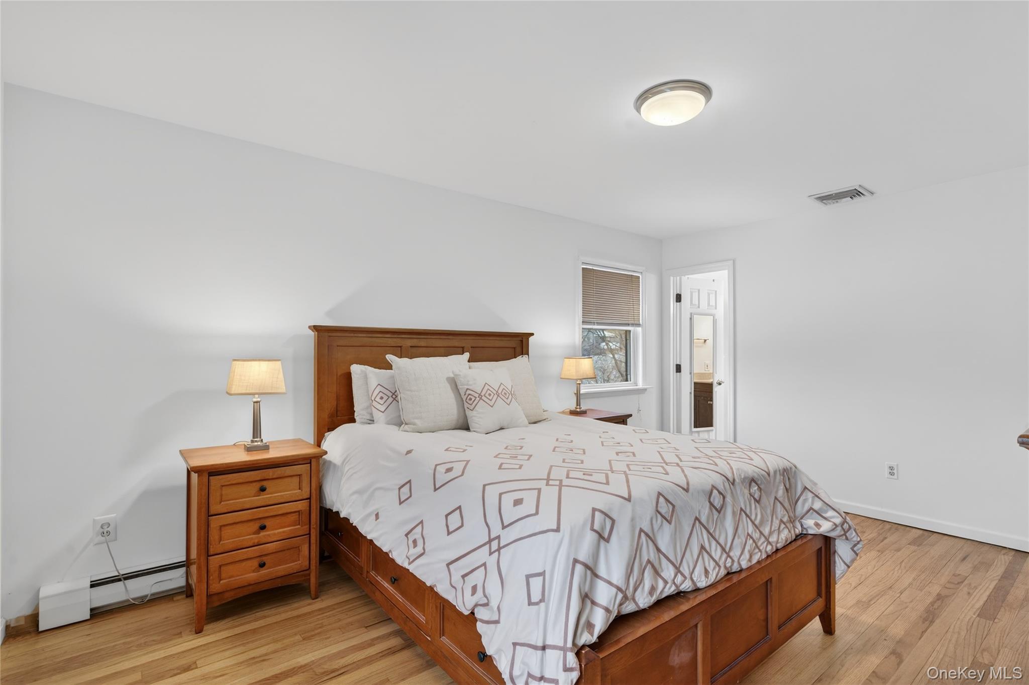100 Watch Hill Drive Fishkill, NY 12524 - Photo 24 of 49 Bedroom featuring a baseboard radiator, light wood-type flooring, and connected bathroom