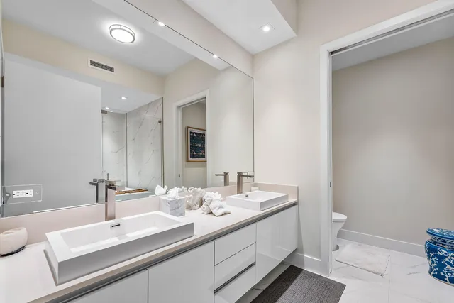 a bathroom with a sink a toilet and a mirror