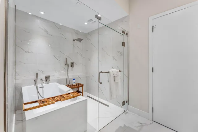 a bathroom with a tub sink vanity and mirror