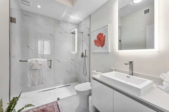 a bathroom with a sink a toilet and shower