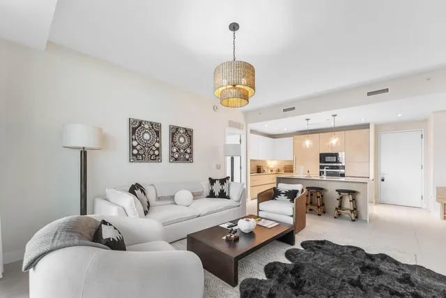 a living room with furniture a chandelier and a table