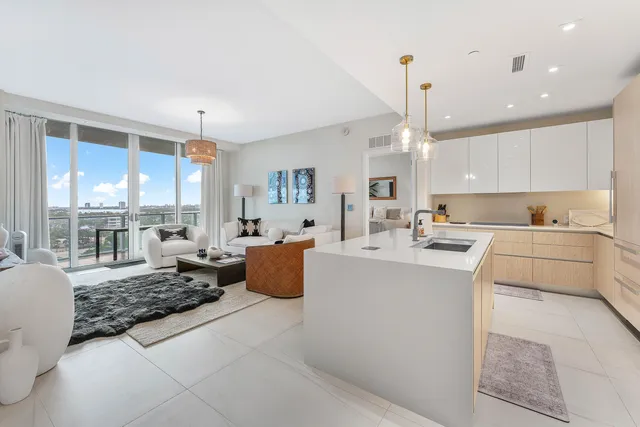 a large white kitchen with a large window cabinets and stainless steel appliances